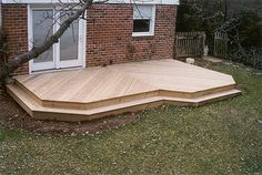 a wooden deck in front of a brick building