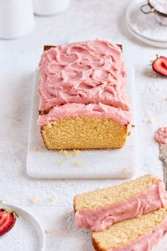 a piece of cake with pink frosting sitting on a plate next to another slice