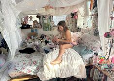 a woman sitting on top of a bed in a room filled with toys and other items