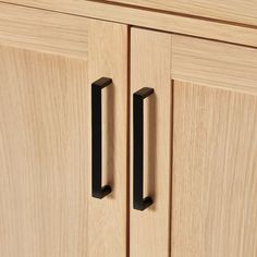 two black handles on a wooden cabinet door