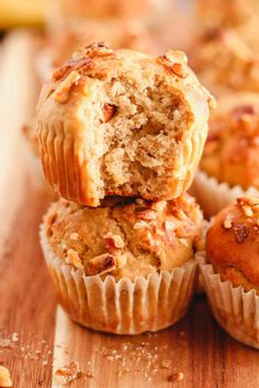 several muffins stacked on top of each other with one bite taken from the muffin