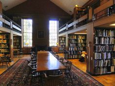 an old library with tables and chairs in front of large bookshelves filled with books