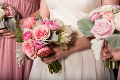 three bridesmaids holding bouquets of pink and white flowers in their hands,