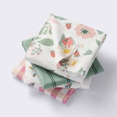 four napkins stacked on top of each other in different colors and patterns with flowers