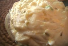 a close up view of some food in a glass jar on a tableclothed surface