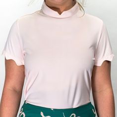 This. Golf. Top. Pronounced "airy-ahn-when", this top stands out in the crowd, just like it's namesake. A mandarin collar ties perfectly with the reversed scallop sleeves to give you a crisp, unique look. Invisible zipper featured on back of neck for collar. Pair with the Ari Skort for full wow effect. Spring Stand Collar Top, Chic Spring Top With Stand Collar, Chic Stand Collar Tops For Spring, Elegant Top With Stand Collar, Chic Fitted Top With Stand Collar, Spring Mock Neck Top With Stretch, Spring Solid Mock Neck Top With Stretch, High Neck Spring Blouse, Feminine High Neck Blouse For Spring