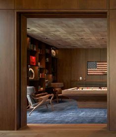 an open door leading to a living room with american flag on the wall behind it