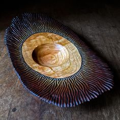 a wooden bowl sitting on top of a wooden table