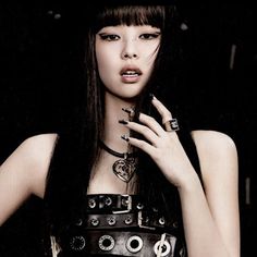 a woman with long black hair and piercings on her fingers is posing for the camera