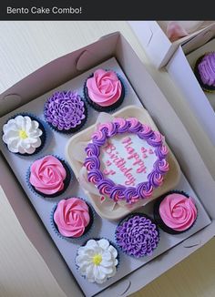 there is a box with cupcakes that are decorated in pink, purple and white icing