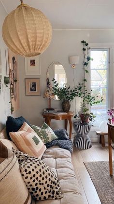 a living room filled with lots of furniture and plants