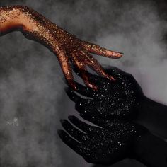 two hands reaching for each other with glitter on them