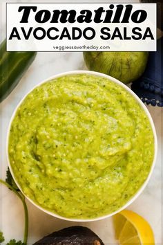 a white bowl filled with guacamole next to sliced limes and cilantro