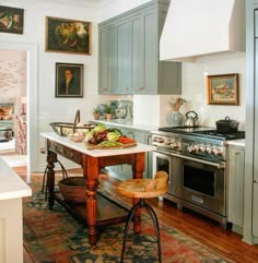 a kitchen with an island in the middle of it and lots of pictures on the wall