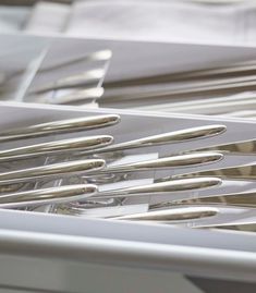 a bunch of silverware sitting in a white container