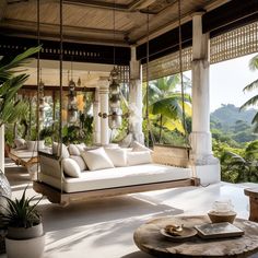 a porch swing bed with pillows on it and hanging plants in the back ground area