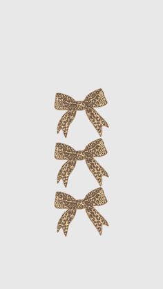 three bows with leopard print on them are hanging from the side of a white wall