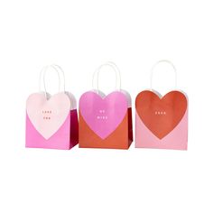 three paper bags with hearts on them, one pink and one orange are in the shape of heart