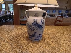 a blue and white vase sitting on top of a kitchen counter next to a lamp