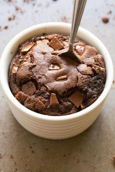 a spoon in a bowl filled with chocolate cake