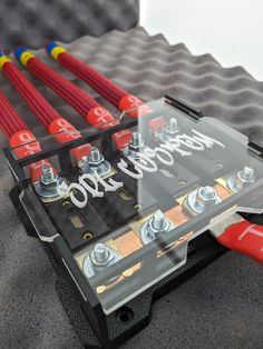 an assortment of tools sitting on top of a piece of plastic with screws in it