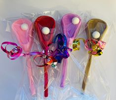 three different colored lollipops wrapped in cellophane and tied with ribbons