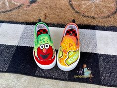 two painted shoes sitting on top of a rug