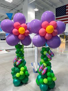 two balloons with flowers on them in the middle of a room