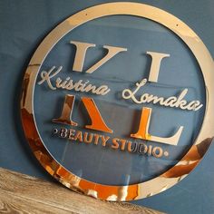 a sign that says k l beauty studio on it's glass plaque above a wooden table