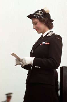 a woman in uniform is reading a piece of paper