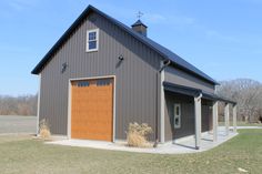 a large gray barn with a brown door and windows