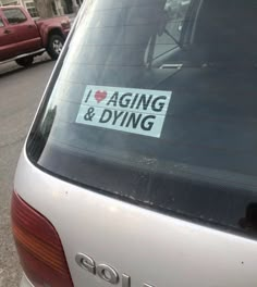 a sticker that says i love aging and dying on the back of a car