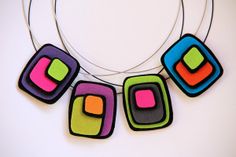 a necklace made out of colorful squares on a white surface with a circular ring around it