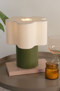 an apple lamp sitting on top of a table next to a wine glass and coaster