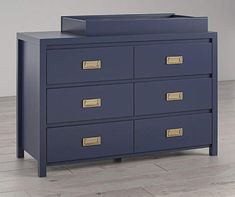 a blue dresser with gold handles and drawers