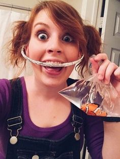 a woman with a fake moustache on her face holding a plastic bag in front of her mouth