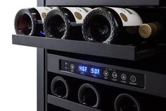 several bottles of wine are stacked on top of each other in a black rack with timers