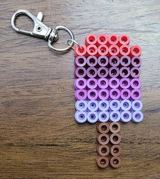 a keychain made out of legos on top of a wooden table next to a pair of scissors