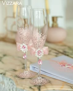 two wine glasses sitting on top of a table next to an open book and notebook