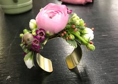 a close up of a pink flower on a table with other items in the background