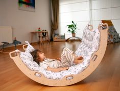 a child laying in a wooden rocking chair