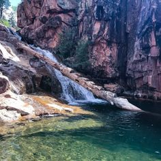 there is a small waterfall coming out of the rocks