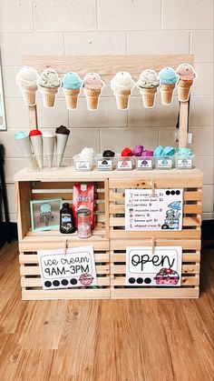 an ice cream stand with two wooden crates holding different types of icecream and cupcakes