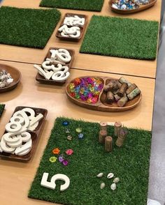 the table is set up with letters and numbers made out of rocks, grass, and stones