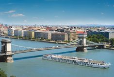 a large boat is on the water in front of a bridge and cityscape