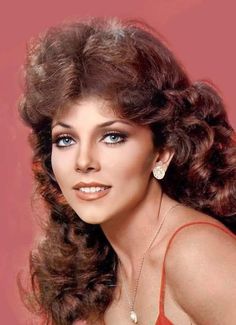 an old photo of a woman with long hair and blue eyes wearing a red dress