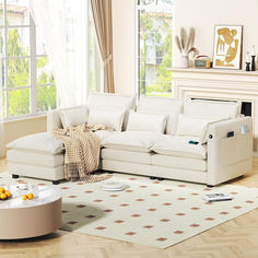 a living room with a white couch and coffee table in front of a window that looks out onto the yard