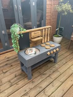 an outdoor kitchen made out of pallets and wooden planks on a deck with potted plants