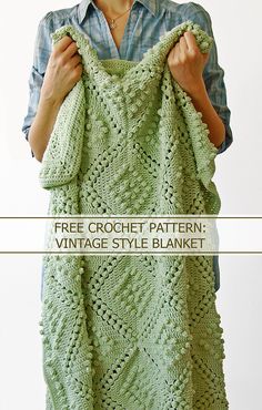 a woman holding up a green crochet shawl with the text free crochet pattern vintage style blanket