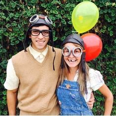 two people are posing for a photo with balloons on their heads and goggles on